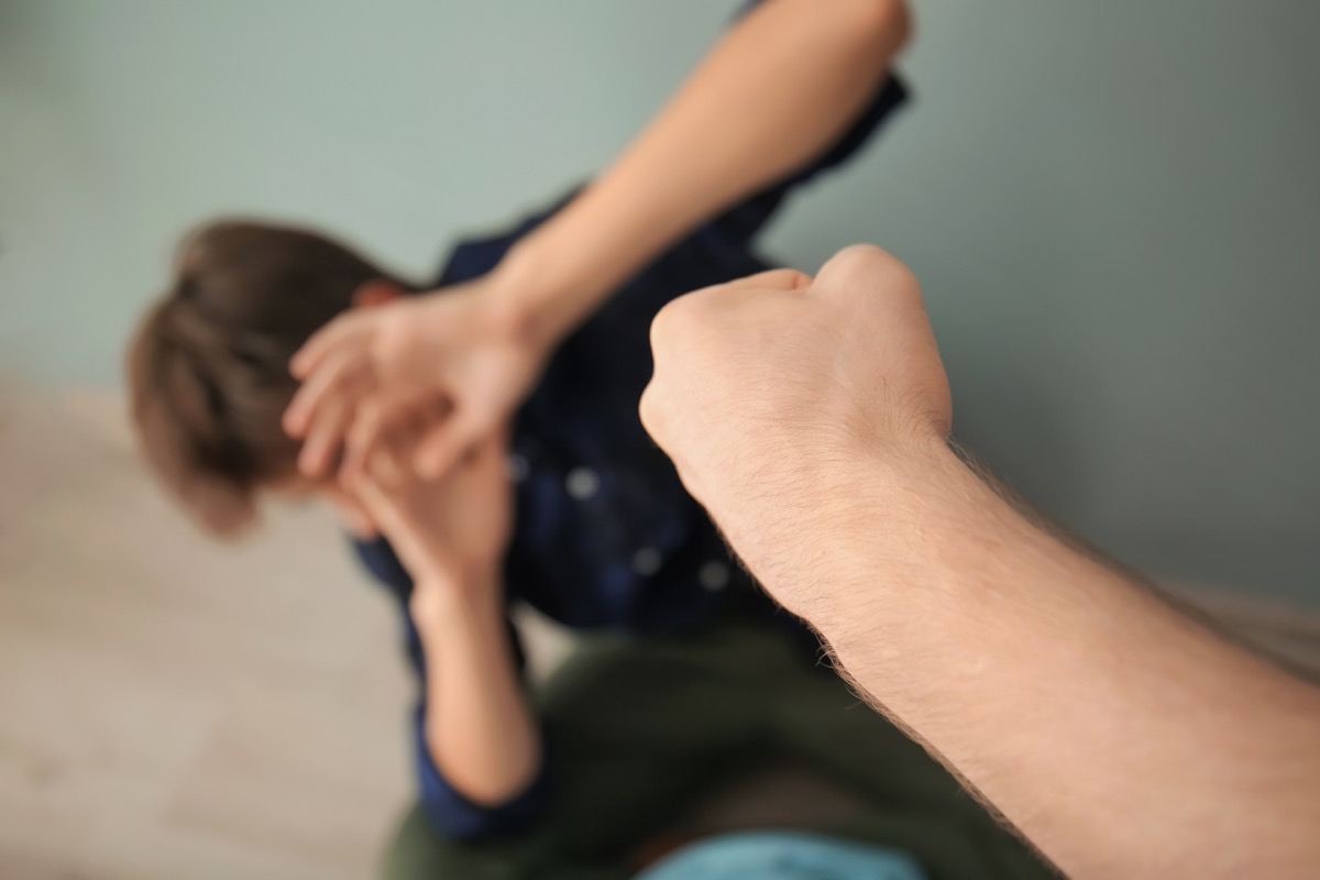 Closeup on fist moving toward cowering teenage boy, 40 year old virgin
