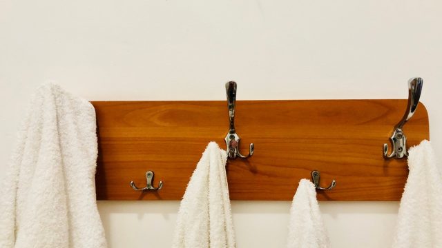 White towels hanging on hooks in bathroom, gross habits