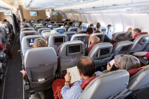 a crowded passenger cabin of an international flight