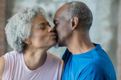 elderly couple kissing each other goodnight