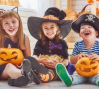 best halloween party games kids adults, kids sitting in costumes with pumpkins