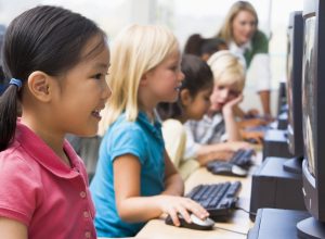 elementary school children in a computer lab with old technology