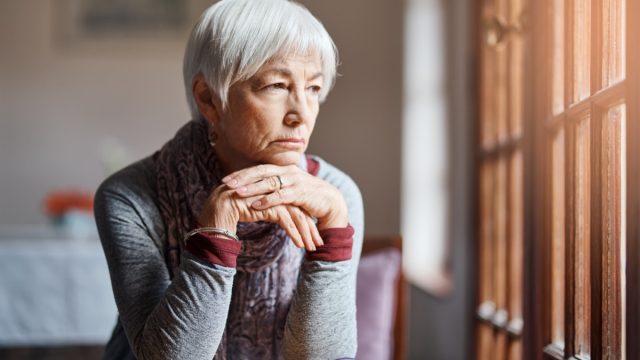older woman staring and thinking out of window