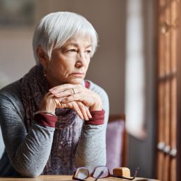 older woman staring and thinking out of window