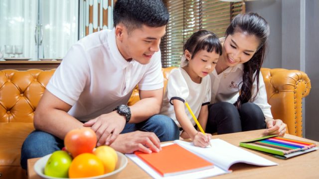 asian parents helping young child with homework, life skills parents should teach kids