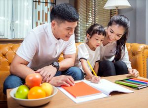 asian parents helping young child with homework, life skills parents should teach kids