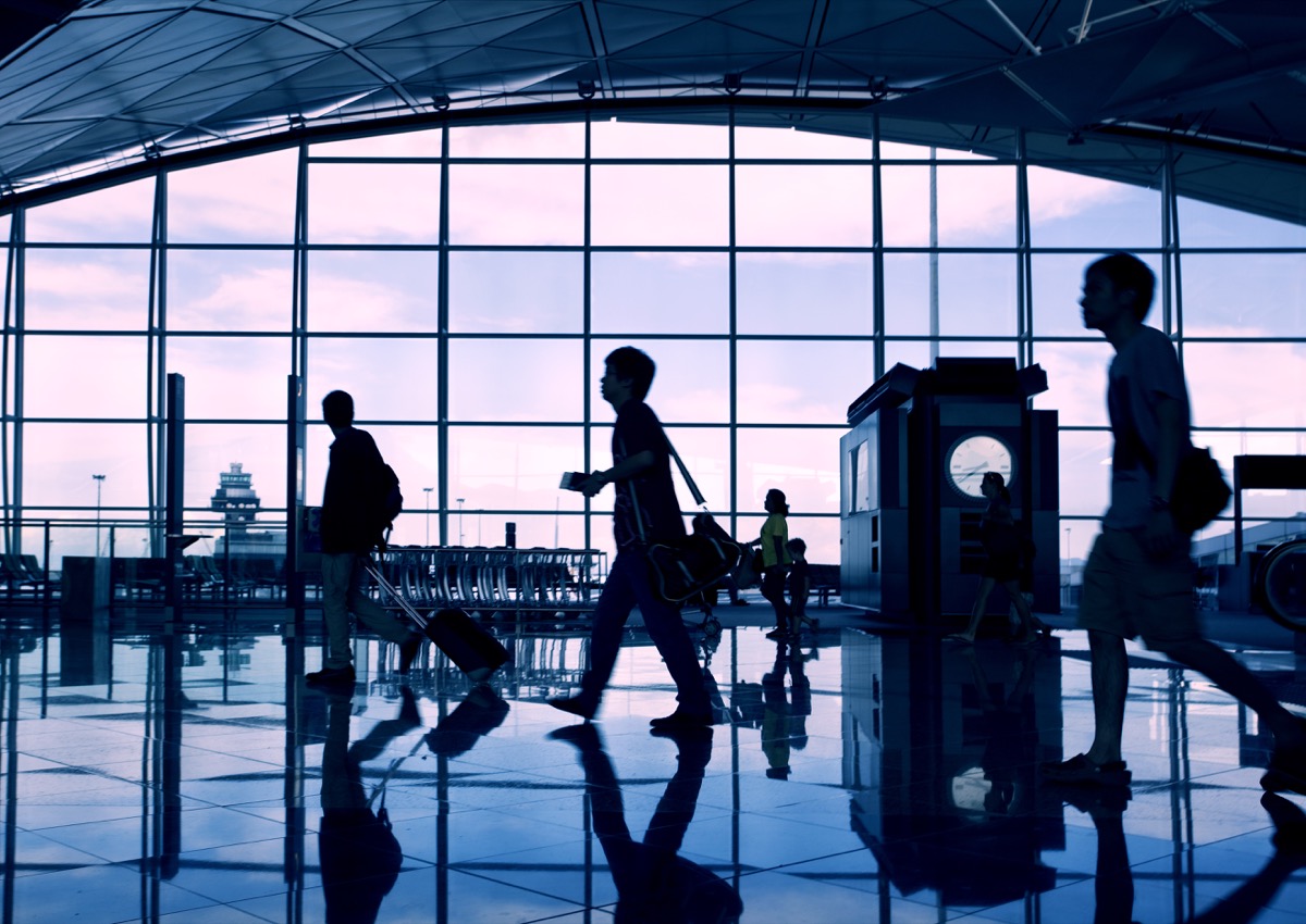 passengers walking in an airport terminal at dusk