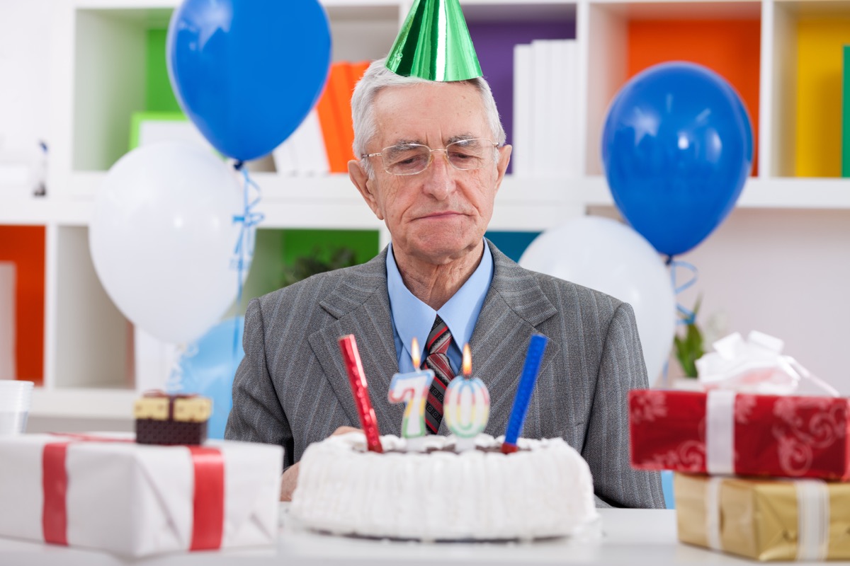 Older man celebrating his 70th birthday looking confused or sad