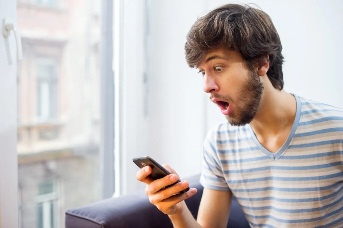 shocked man looking at phone, different word meanings