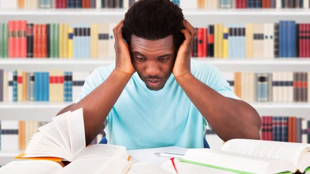 African American college student looking stressed in the library ways college is different