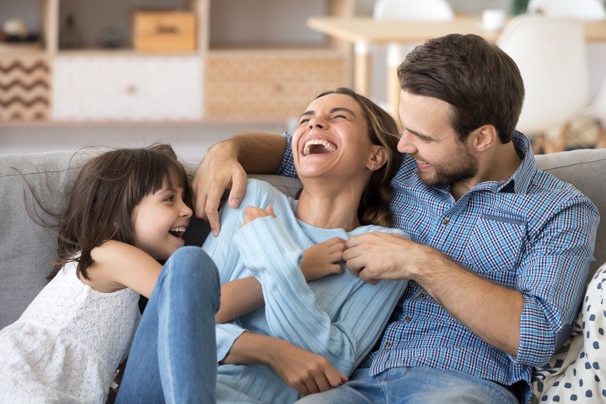 Dad and daughter tickling mom