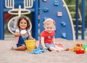 two toddlers playing in sand on playground, best outdoor toys for toddlers
