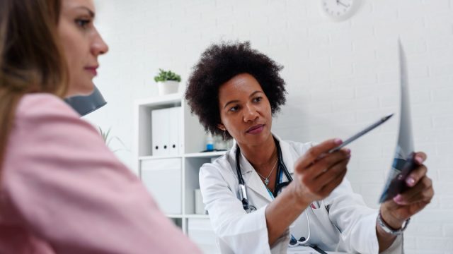 Doctor talking with patient at desk in medical office