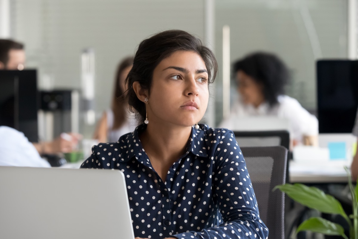 Indian woman staring into space distracted at work