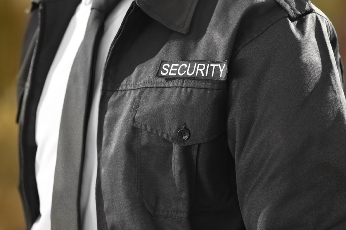 Closeup of bodyguard's chest with "Security" tag and tie