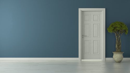 Closed interior white door amid blue wall