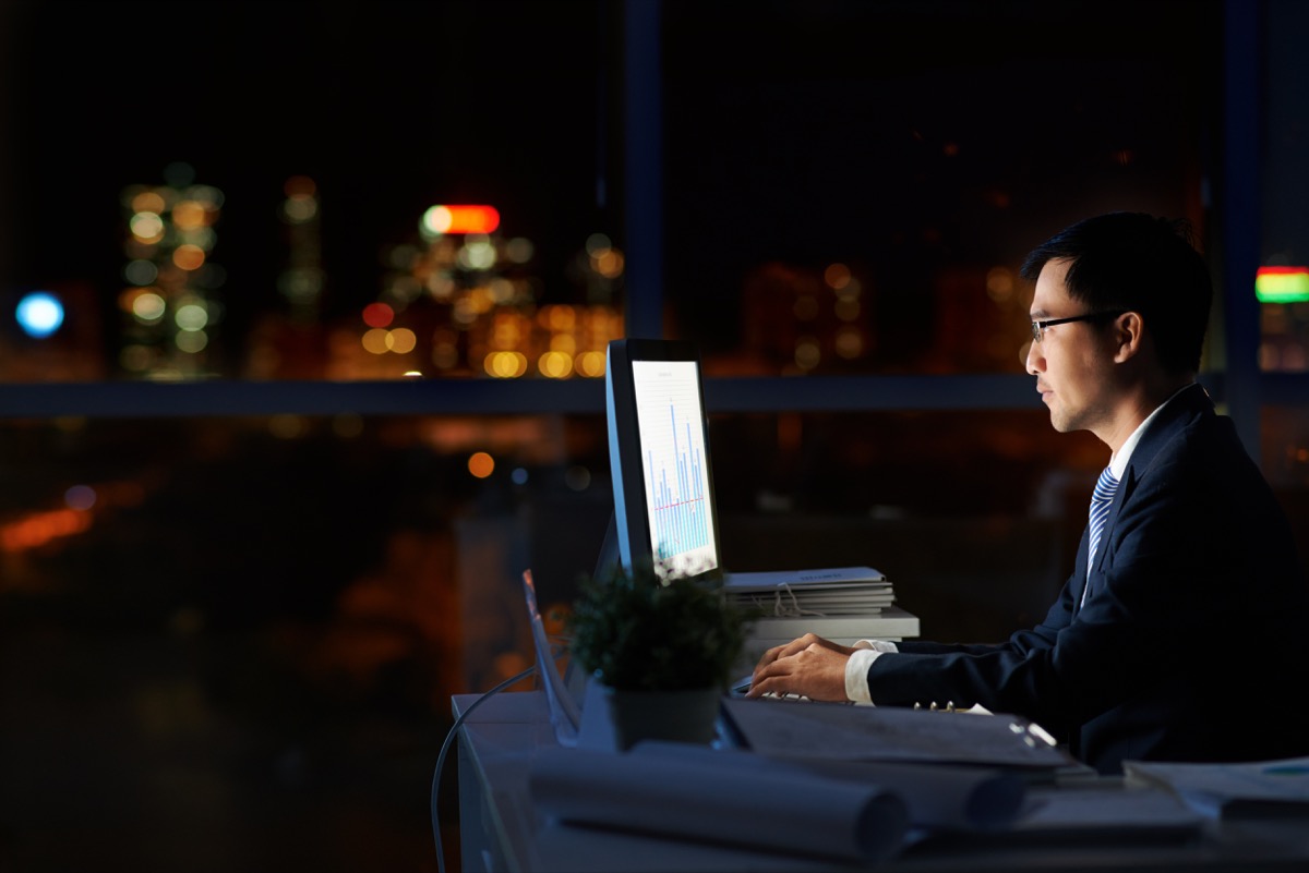 Man Working Alone in a Dark Office at Night