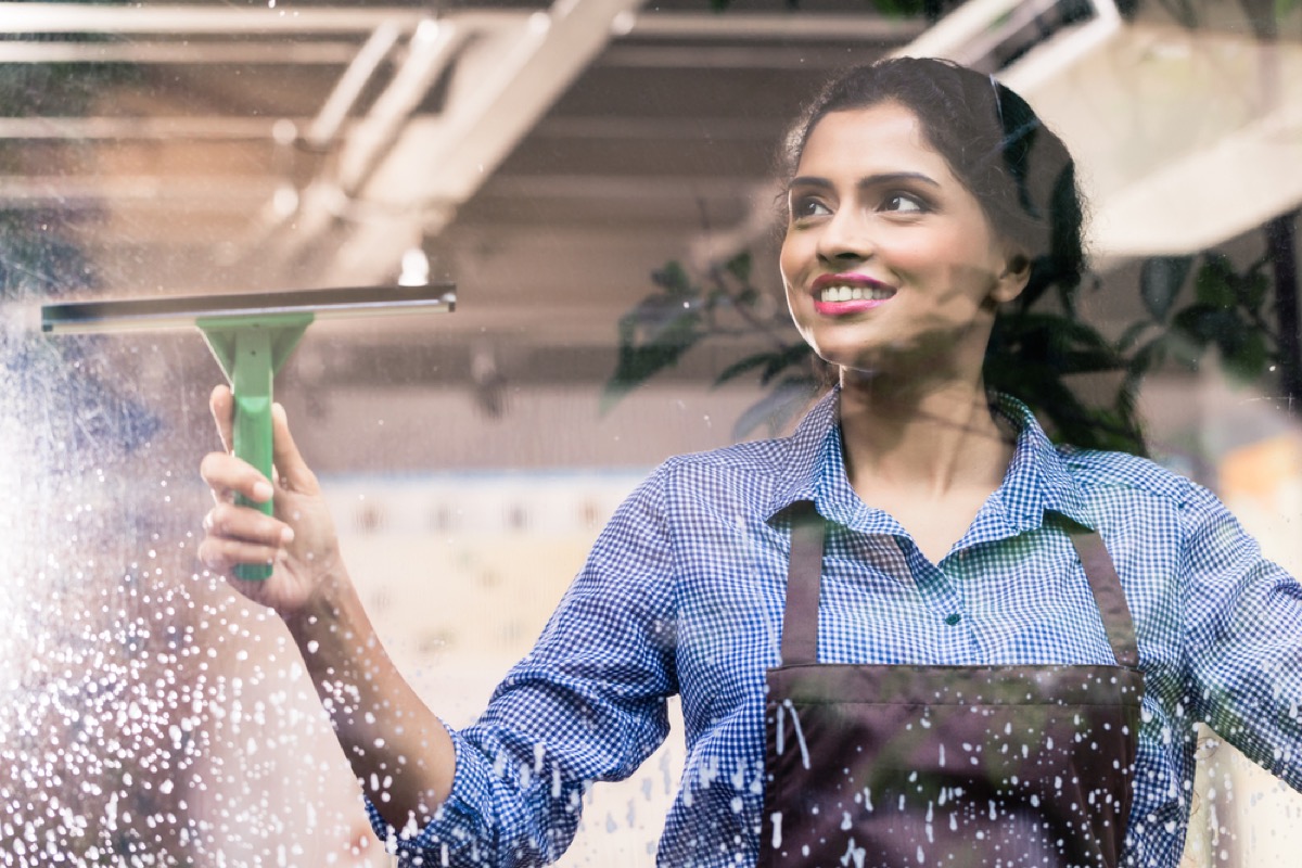 woman in black apron cleaning window with a squeegee, things husband should notice
