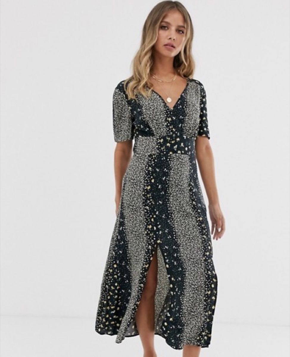 blond model with wavy hair wearing long black dress with white dots on it