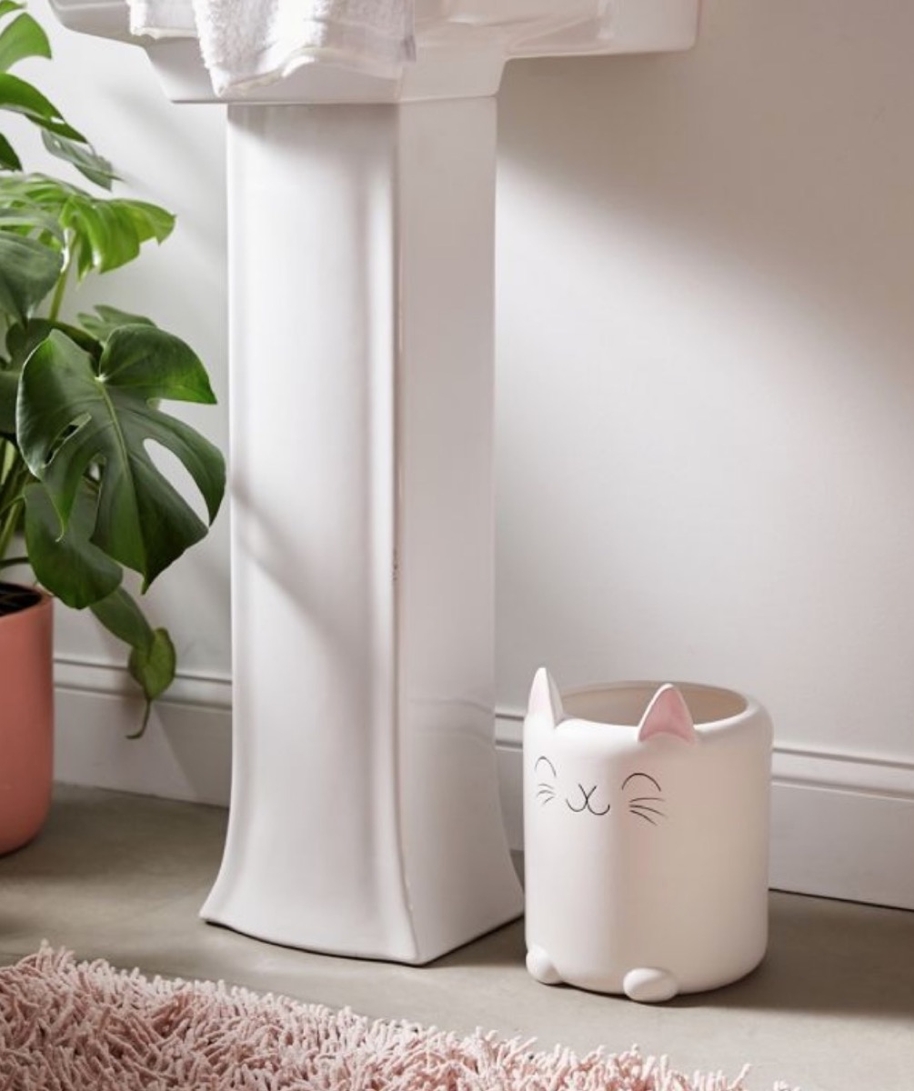 pink ceramic cat trash can next to white pedestal sink, cat gifts