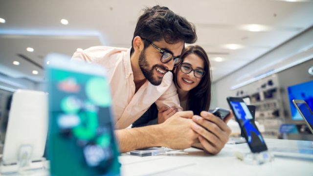 man and woman looking at phone on white sales counter