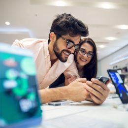 man and woman looking at phone on white sales counter