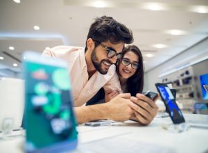 man and woman looking at phone on white sales counter