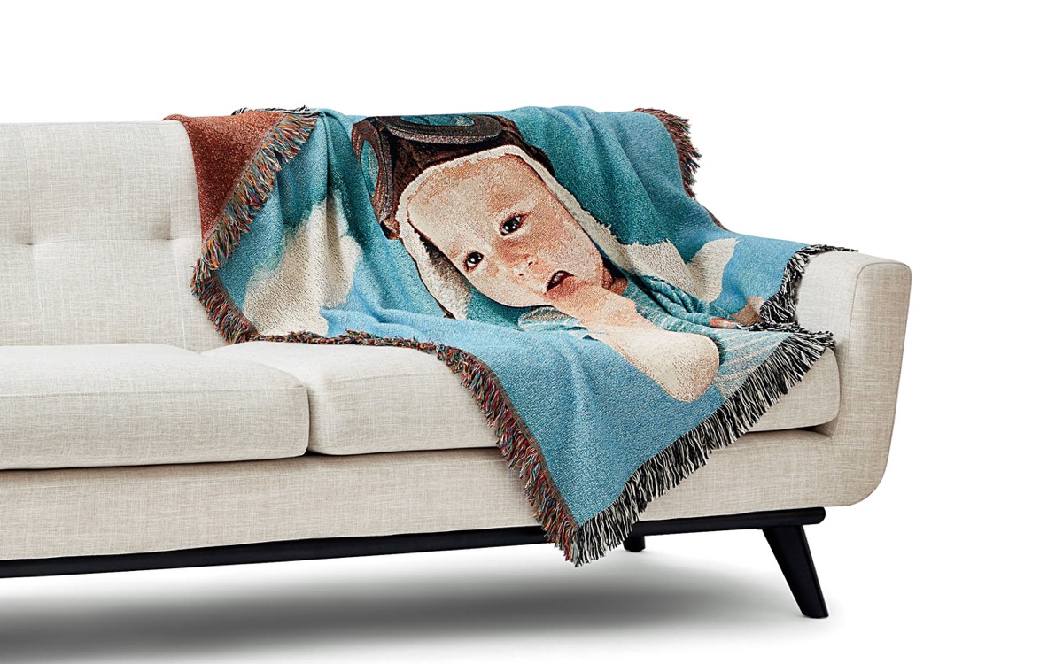 white couch with blanket with baby photo wearing aviator goggles on it, best gifts for grandparents