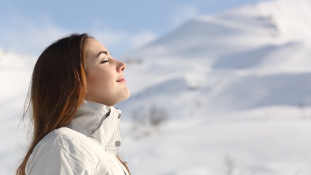 Woman taking a deep breath outside in the winter