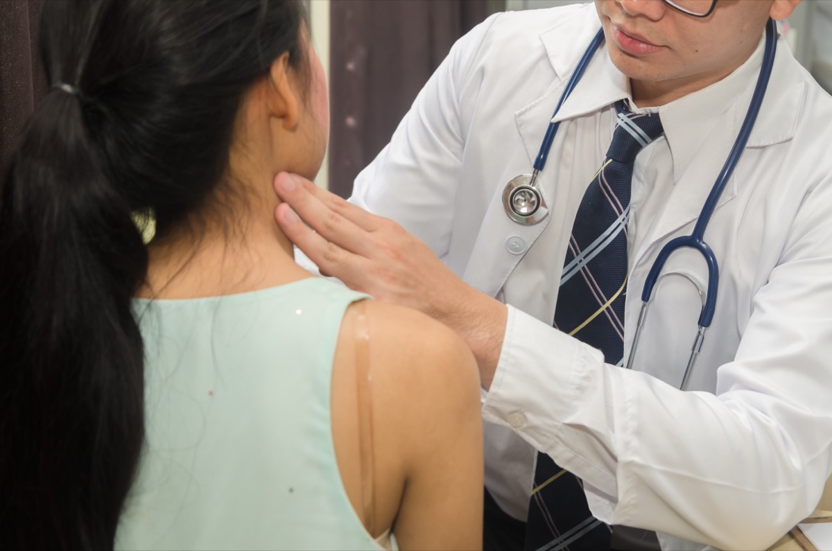 Doctor checking patient's neck