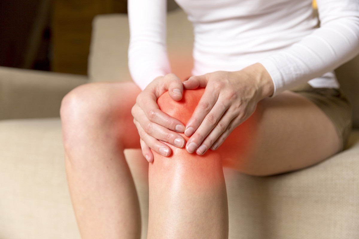 woman holding her knee because its painful and inflamed