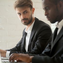 Jealous Male Coworker Looking at a Fellow Employee Things He Won't Admit