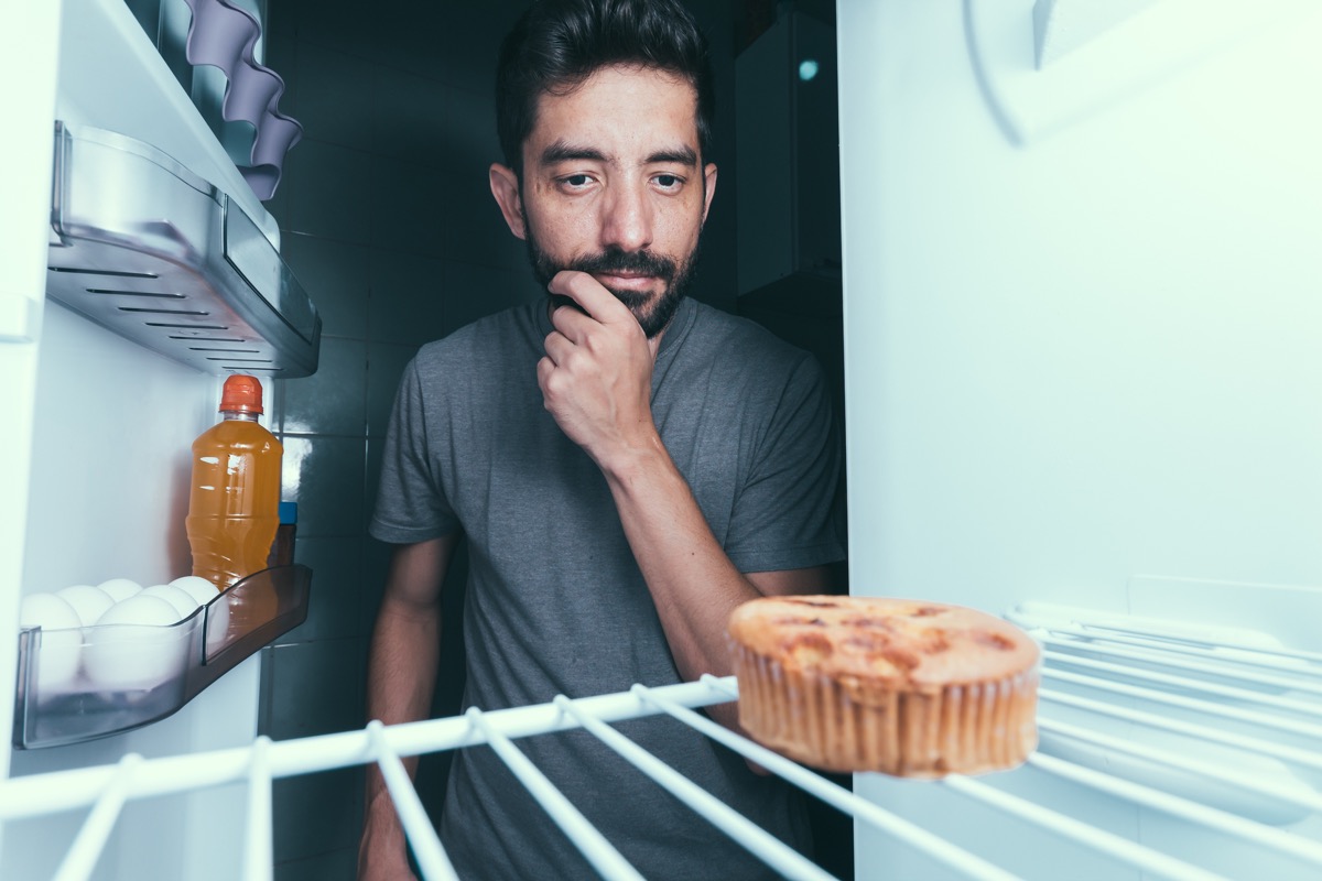 man eating late-night snack things you're doing that would horrify sleep doctors