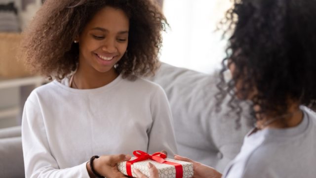 mom giving teenage daughter gift-wrapped box, prepare children for divorce