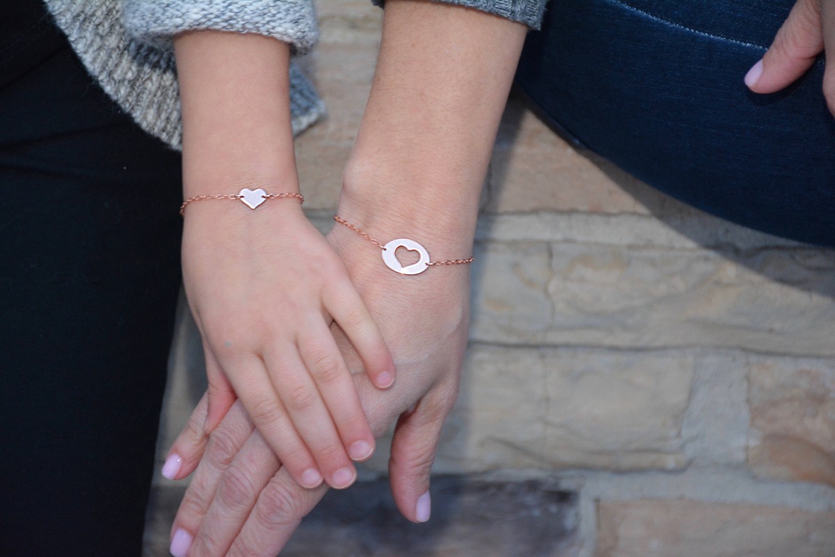 child holding her mother's hand with matching bracelets on, mother daughter gifts