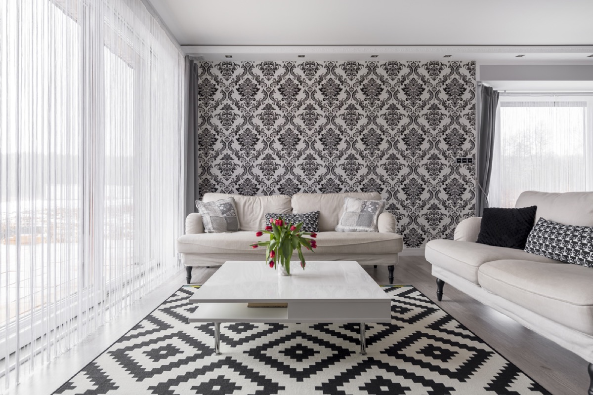 black and white living room with clashing patterns and two white couches