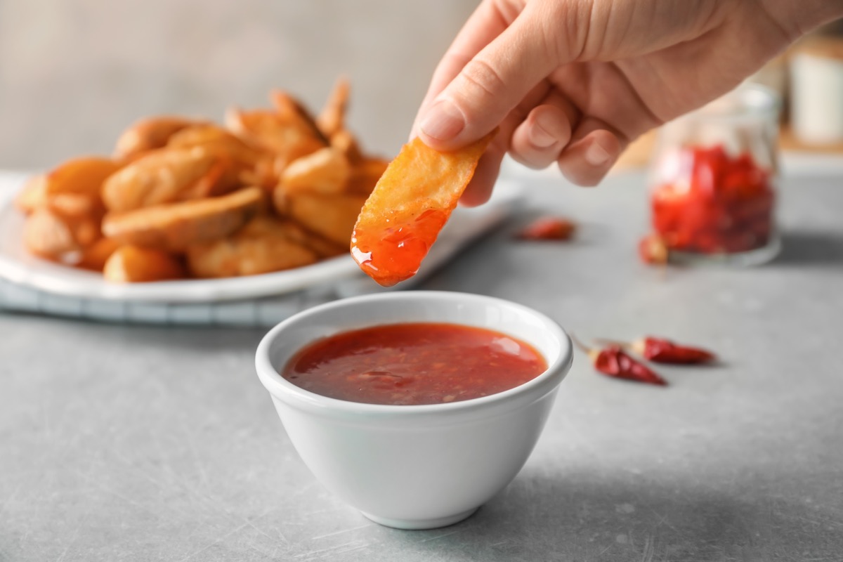 person dipping french fry into ketchup old-fashioned manners
