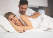 mean and woman in bed looking pensive - what your cheating dream means