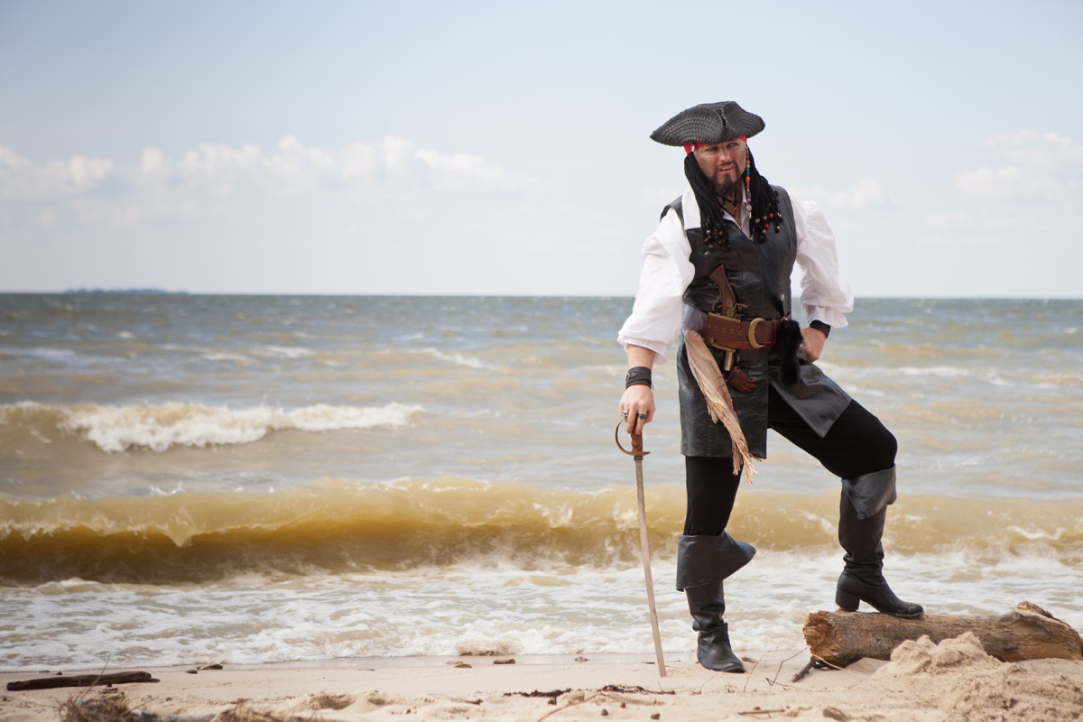 Man dressed as pirate on beach