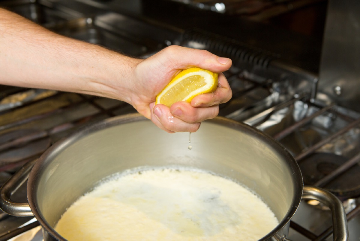 hand squeezing lemon into pan, old fashioned cleaning tips