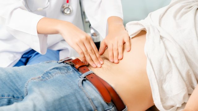 Doctor checking patient's stomach