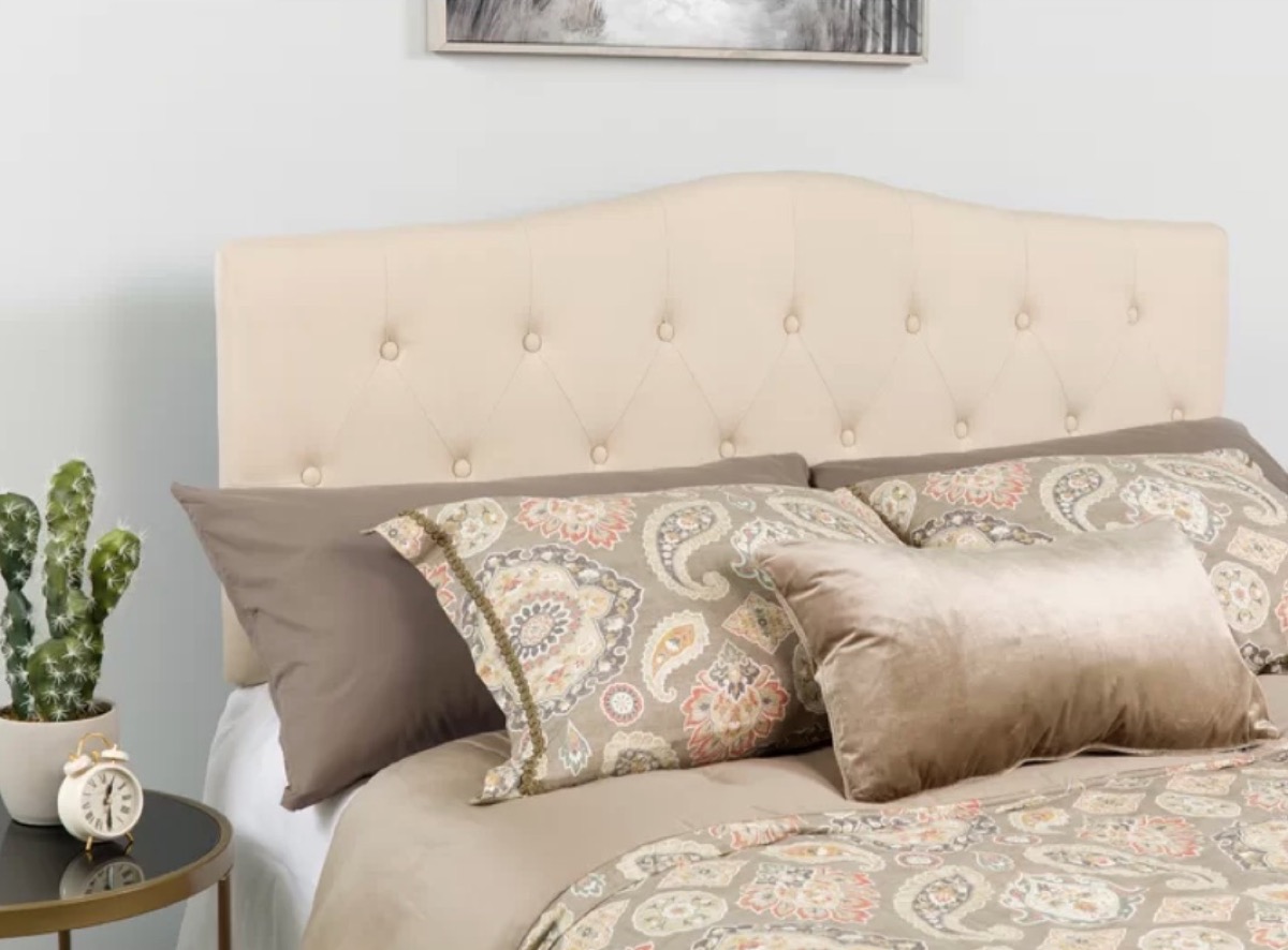 brown pillows against a tufted white headboard