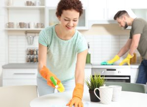 white couple cleaning kitchen in modern home