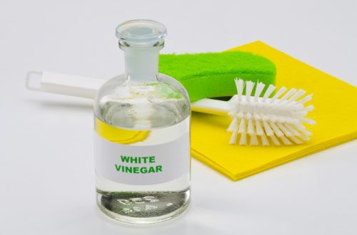 white vinegar and sponges on white background