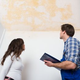 white woman and man looking at stained ceiling