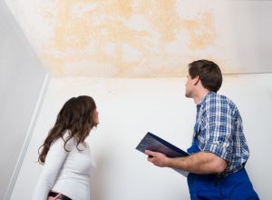 white woman and man looking at stained ceiling