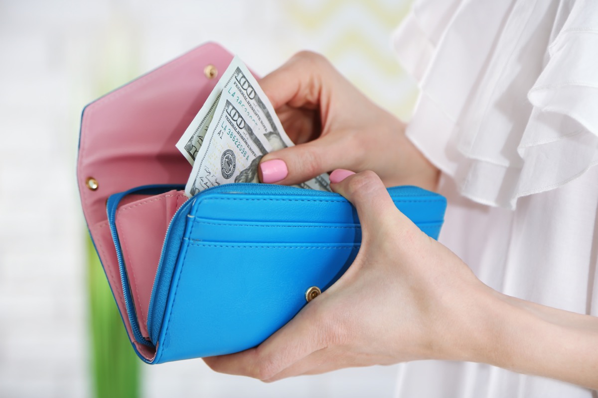 woman putting money in her wallet