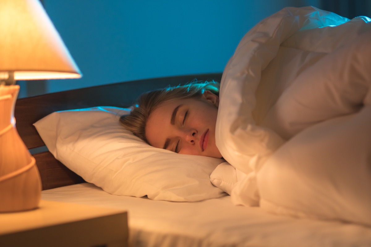 woman sleeping with light on in bedroom