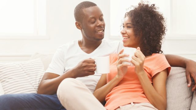 young black couple drinking coffee at home