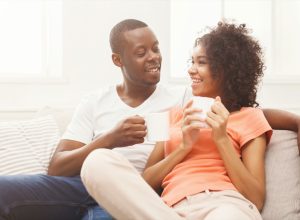 young black couple drinking coffee at home